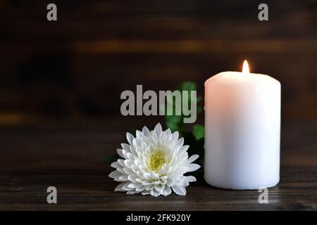 Carte de condoléances avec bougie et fleur blanche de chrysanthème Banque D'Images