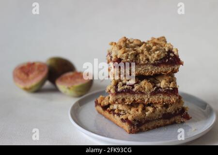 Barres de crumble de figues maison faites de figues fraîches et de farine de blé entier. Prise de vue sur fond blanc. Banque D'Images