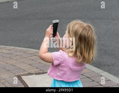 Petite fille prend une photo avec un smartphone Banque D'Images