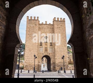 Vue sur le pont médiéval d'Alcantara à travers le Tage à Tolède à travers l'une des arches dans le mur, Espagne. Banque D'Images