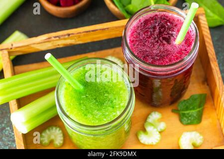 Boissons végétariennes, régime et nutrition végétaliens, concepts de détox sains. Smoothie aux betteraves et smoothie vert céleri et épinards sur fond de pierre. Banque D'Images