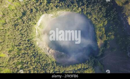 Un tir de haut en bas de drone du lac cratère du volcan Kelimutu à Flores, en Indonésie. Brume blanche mystique remplissant le cratère au-dessus du lac Abutu. Naturel Banque D'Images