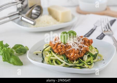 Zoodles bolognese: Nouilles courgettes avec viande ou sauce à la viande de soja végétalienne et parmesan. Pour une alimentation faible en glucides, keto et paléocarbe. Banque D'Images