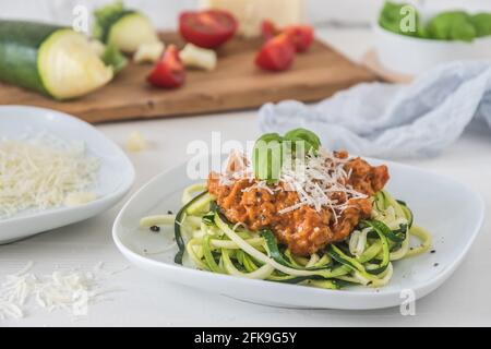 Zoodles bolognese: Nouilles courgettes avec viande ou sauce à la viande de soja végétalienne et parmesan. Pour une alimentation faible en glucides, keto et paléocarbe. Banque D'Images