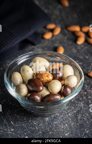 Amandes au chocolat doux. Œufs au chocolat dans un bol sur une table noire. Banque D'Images