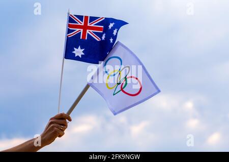 Fan orrant le drapeau national de l'Australie et le drapeau olympique avec des anneaux de symboles jeux olympiques. Banque D'Images