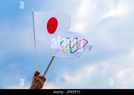 Fan signe le drapeau national du Japon et le drapeau olympique avec le symbole anneaux olympiques. Banque D'Images