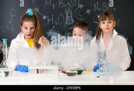 trois enfants excités après une expérience chimique Banque D'Images