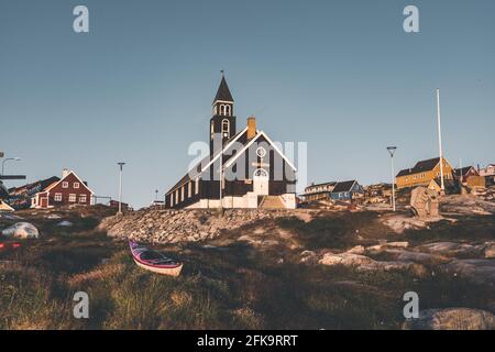 Ancienne église en bois de Zions dans la ville arctique d'Ilulissat, avec lumière du soleil de minuit et ciel bleu dans le nord du Groenland Banque D'Images