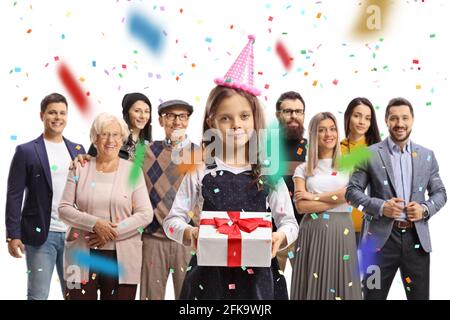 Petite fille tenant un cadeau d'anniversaire et des gens debout derrière isolé sur fond blanc Banque D'Images