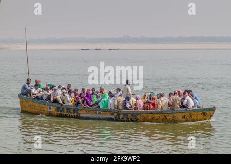 VARANASI, INDE - 25 OCTOBRE 2016 : petit bateau transportant des personnes locales près des marches du fleuve Ghâts menant aux rives du Gange à Varanasi, Banque D'Images