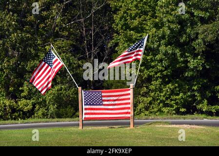 Le drapeau américain est monté entre deux poteaux en bois. Au-dessus des poteaux, sont deux poteaux de drapeau chacun avec un autre drapeau américain. Banque D'Images