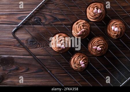 Délicieux cupcakes au chocolat noir, garniture en coeur de sucre, table texturée en bois. Boulangerie cacao, grille rustique étagère café-restaurant hippster table Banque D'Images