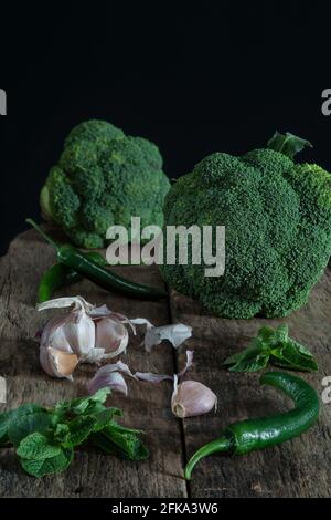 Encore la vie avec le brocoli vert, les piments, l'ail et la menthe sur le bois Banque D'Images