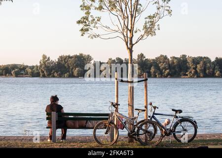 Photo d'un vieux couple, homme et femme, dormant et ayant une pause sur un banc après avoir fait du vélo au bord du danube à Belgrade, serbie. Banque D'Images