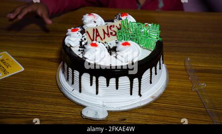 Gâteau d'anniversaire crémeux au sucre au design attrayant. Gâteau d'anniversaire blanc avec couche crème colorée sur fond blanc. Banque D'Images