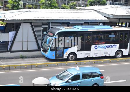 Senayan, Jakarta Indonésie, 23 avril 2021 : un bus Transjakarta blanc et bleu s'est arrêté à l'arrêt. Banque D'Images