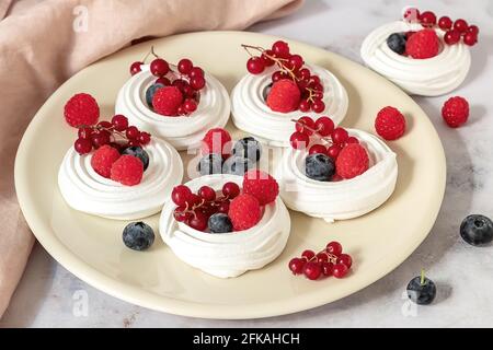 Meringues fraîches ou mini Pavlova sur la plaque. Banque D'Images