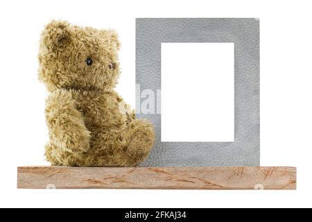 Profil latéral d'un adorable ours assis à côté d'un cadre d'image en métal vierge en véritable argent, isolé sur fond blanc Banque D'Images