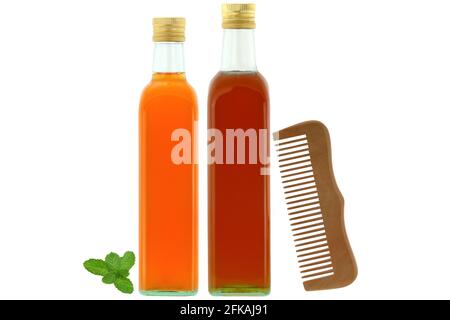 Bouteilles de vinaigre de cidre de pomme biologique cru et non filtré avec enzymes maternelles, miel biologique à côté du peigne en bois, ingrédients pour cheveux secs et abîmés Banque D'Images