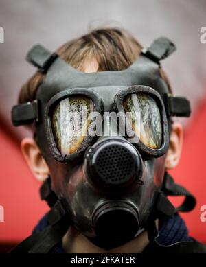 Image de faible profondeur de champ (mise au point sélective) avec un masque à gaz militaire ancien et usé sans filtres sur le visage d'un homme. Banque D'Images