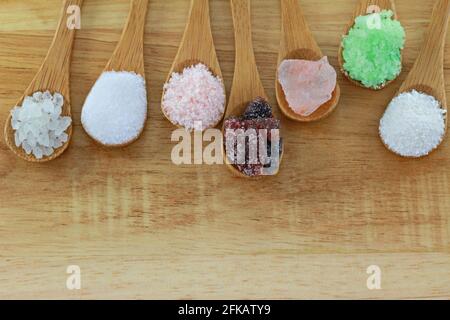 Spoons of commercial salt and natural rock salt on a wooden background Banque D'Images