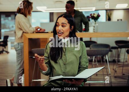 une femme d'affaires passionnée qui instruit les clients pour leur présenter avant rencontre avec le patron Banque D'Images