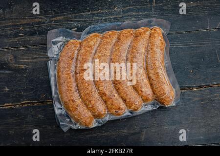 Saucisses à la viande emballées sous vide ou kupaty sur un fond en bois. Gros plan. Banque D'Images