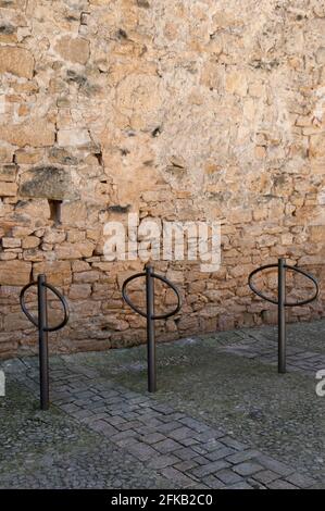 Trois porte-vélos dans une rangée devant un Vieux mur en pierre de couleur miel Banque D'Images