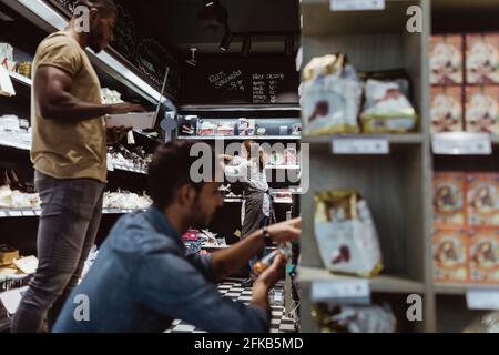 Collègues hommes et femmes travaillant à la épicerie fine Banque D'Images