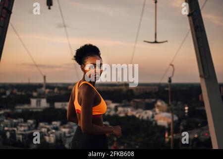 Portrait de l'athlète féminine contre le ciel au coucher du soleil Banque D'Images