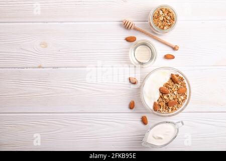 Bol en verre avec yaourt grec et mélange de noix. Sports sains régime végétarien riche en protéines, petit déjeuner maison en granola avec lait, amande, noix de cajou, noisette Banque D'Images