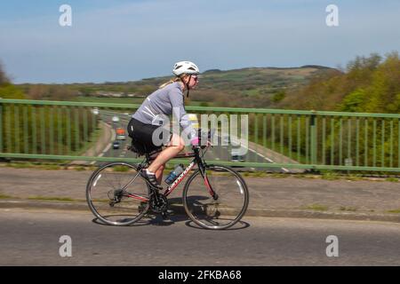 Cycliste féminine à bord de Cannondale sport moto sur route, flou, vitesse d'obturation faible, flou de mouvement, flou, Vélo, vélo, châssis de vélo en fibre de carbone, châssis de vélo composite monocoque, vélo rapide, vélo à grande vitesse, vélo en campagne traversant le pont autoroutier dans la région rurale de Lancashire, Royaume-Uni Banque D'Images