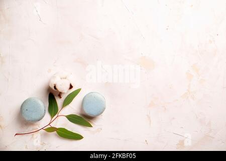 Composition élégante de macarons français eucalyptus et coton Boll sur une table texturée en plâtre de stuc blanc. Joyeux anniversaire de Saint-Valentin cadeau de printemps. Copier Banque D'Images