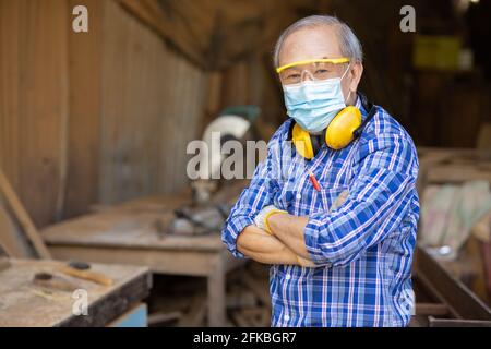 Portrait de travailleur du bois aîné passe-temps pour une bonne retraite, homme asiatique mature maître professionnel du bois artisanat mobilier en bois fabricant de bois homme. Banque D'Images