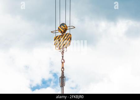 Levage d'un équipement lourd mécanisme de levage d'une grue à tour avec un crochet et une chaîne contre le ciel. Gros plan. Banque D'Images