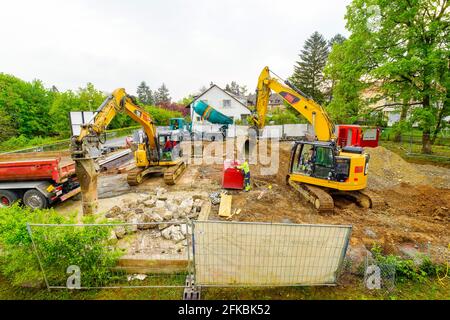 Destruction de la vieille maison pour en construire une nouvelle. Un bulldozer lourd déchire une villa et libère de l'espace pour un nouveau bâtiment. Riehen, Suissel Banque D'Images