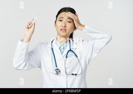 femme médecin dans une robe médicale avec un stéthoscope autour son cou gestuelle avec ses mains Banque D'Images