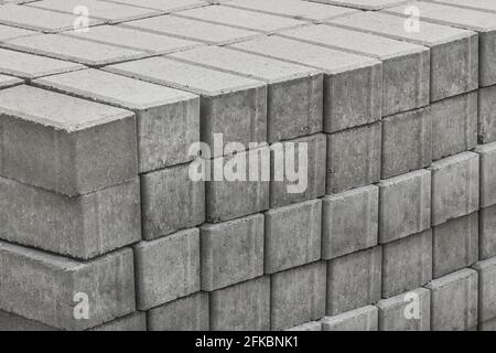 Une pile de dalles de pierre à paver conditionnées de matériaux de trottoirs pour carreaux industriels sur un chantier de construction. Banque D'Images