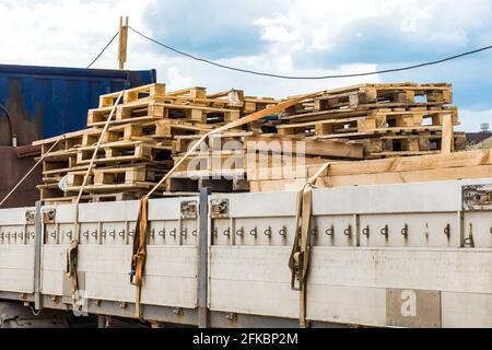 Camion sur le chantier transportant des palettes en bois, du fret industriel ou du fret en bois. Banque D'Images