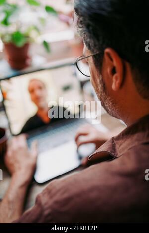 Homme d'affaires sur la vidéoconférence avec un collègue à la maison pendant pandémie Banque D'Images