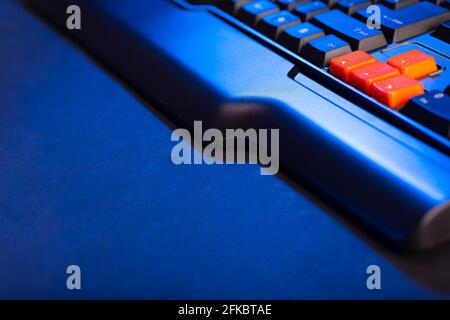 Touches fléchées orange sur un clavier noir, touches haut, bas, gauche, droite sur un clavier d'ordinateur de jeu. Banque D'Images