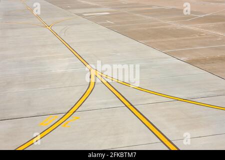 Les lignes de taxis jaunes de l'aéroport sont inscrites sur le tablier sur l'asphalte en béton, signe pour les pilotes d'avion Banque D'Images