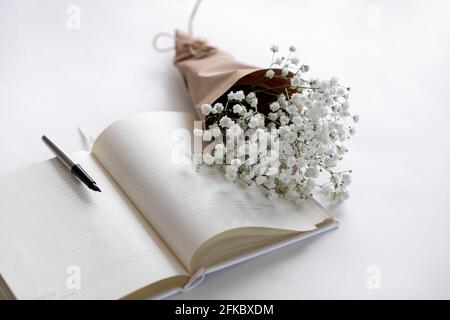 Maquette sur fond de bois blanc avec fleurs et plantes douces. Jolie image féminine. Espace vide. Banque D'Images