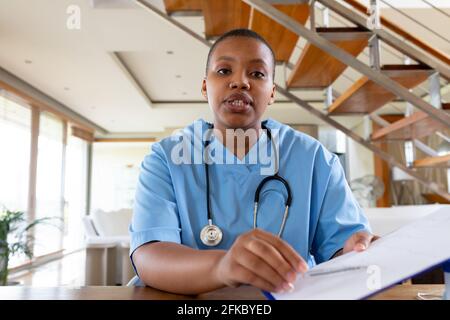 Femme afro-américaine médecin donnant consultation par appel vidéo à regarder appareil photo Banque D'Images