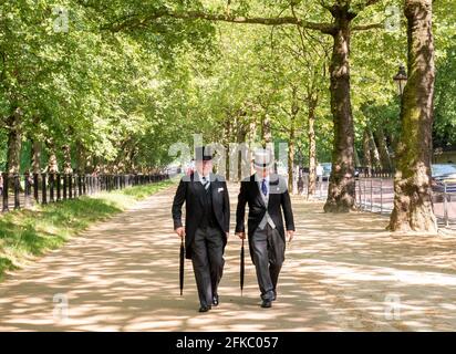 Les hommes en costume et haut de forme matin flânant dans Constitution Hill aux côtés de Green Park, London, UK Banque D'Images