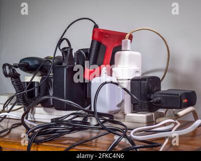 Alimentation électrique de 240 volts non sécuritaire et surchargée au Royaume-Uni, avec un ensemble de fiches, prises, rallonges, fils et câbles, tous branchés sur une carte d'extension. Banque D'Images