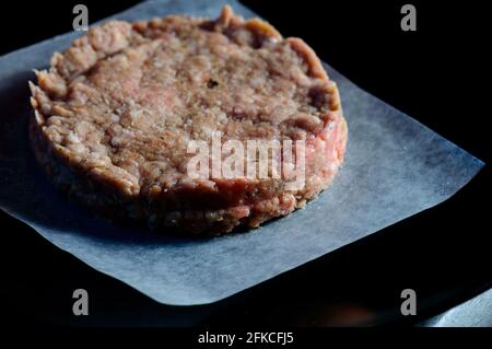 Hamburger de bœuf cru pressé à la main fait maison sur du papier de graissage