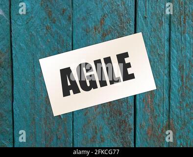 Carte de visite papier avec texte AGILE , gros plan sur fond en bois. Concept d'entreprise Banque D'Images