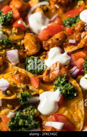 Poulet indien fait maison Tikka Masala Nachos avec chutney et maïs Banque D'Images